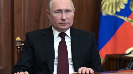 vladimir putin seated at a desk