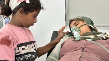 A little girl comforts her mother after they were wounded in a strike north of Nuseirat camp in Gaza.